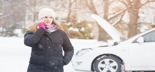 Woman calling breakdown services in the snow