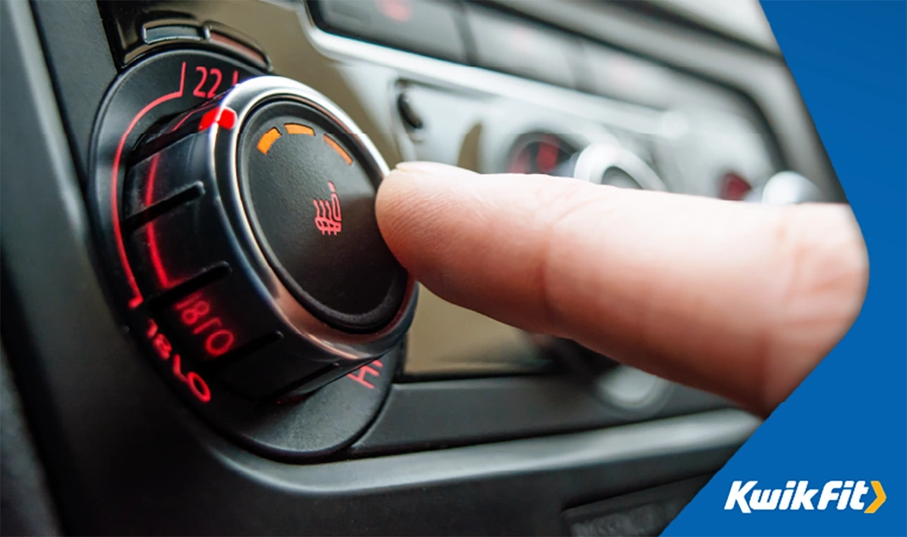 Person pressing the heated seats button in a car.